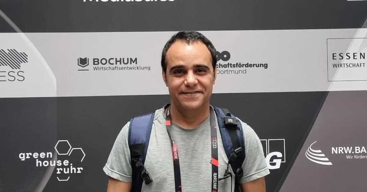 Mojtaba Pourshiri in front of the partner backdrop at r26 in Bochum